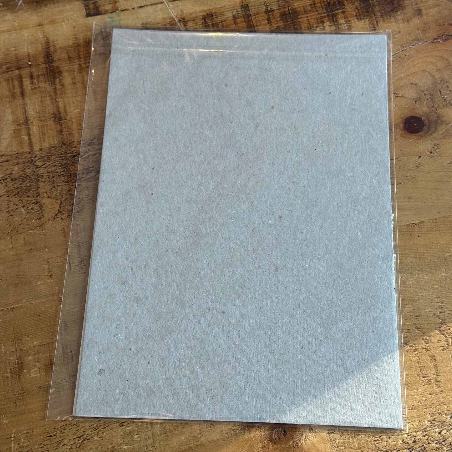 Sheet of gray paper on a wooden surface