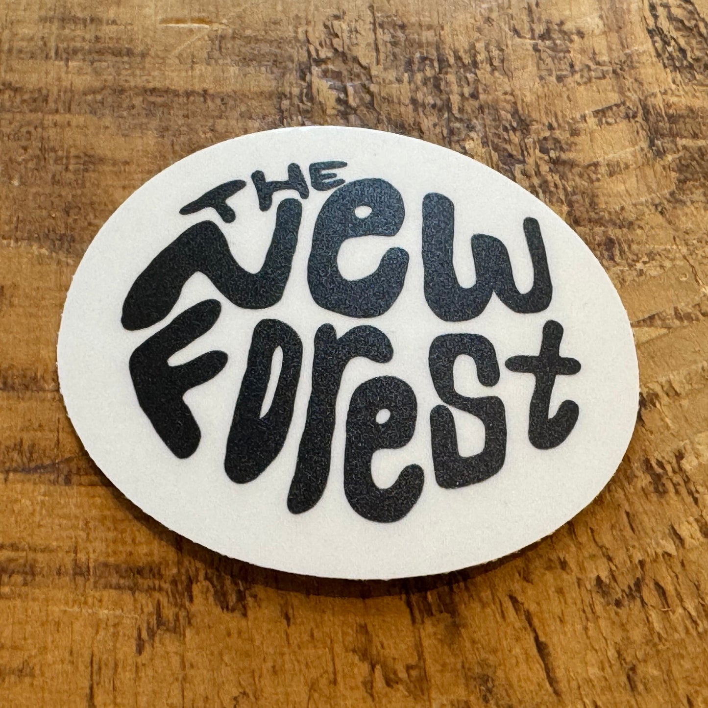 The New Forest Typography Circle Sticker (Clear) Black on Desk