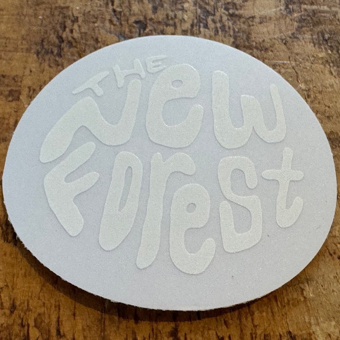 The New Forest Typography Circle Sticker (Clear) White on Desk