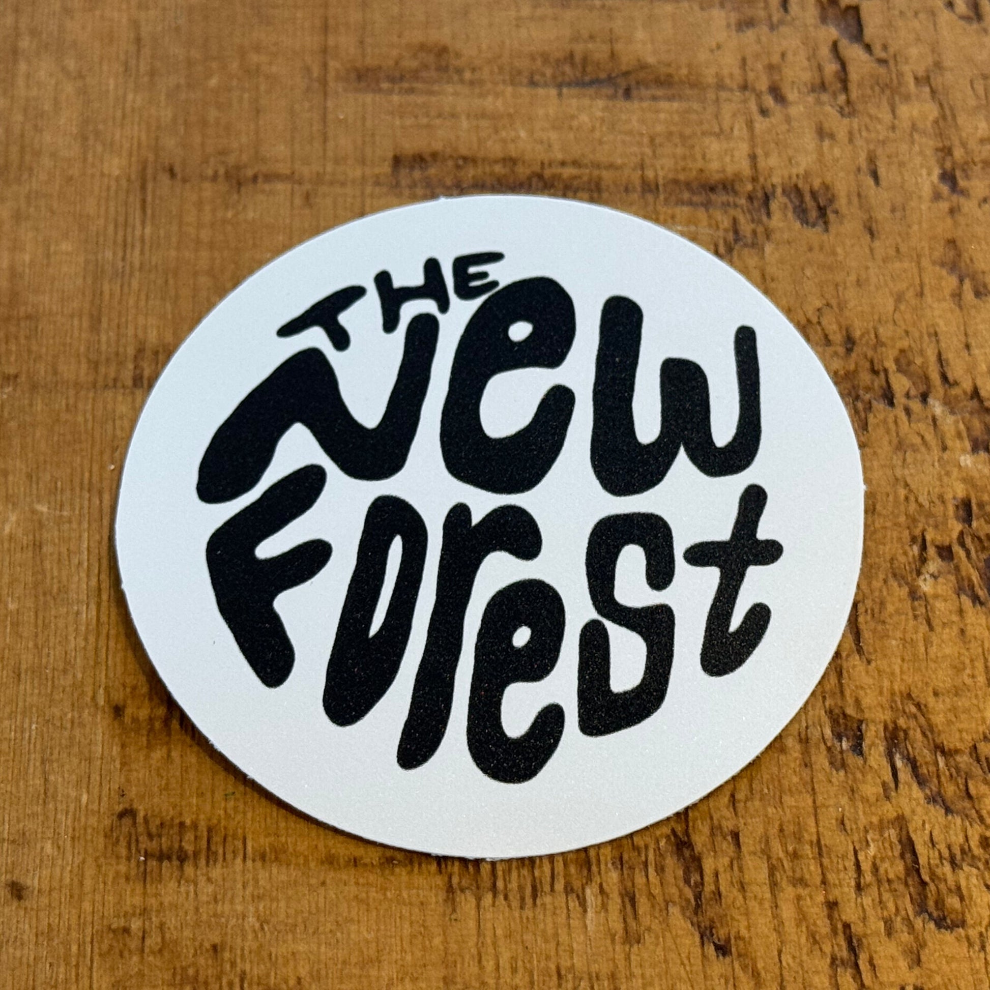 The New Forest Typography Circle Sticker (Solid) Black/White on Desk