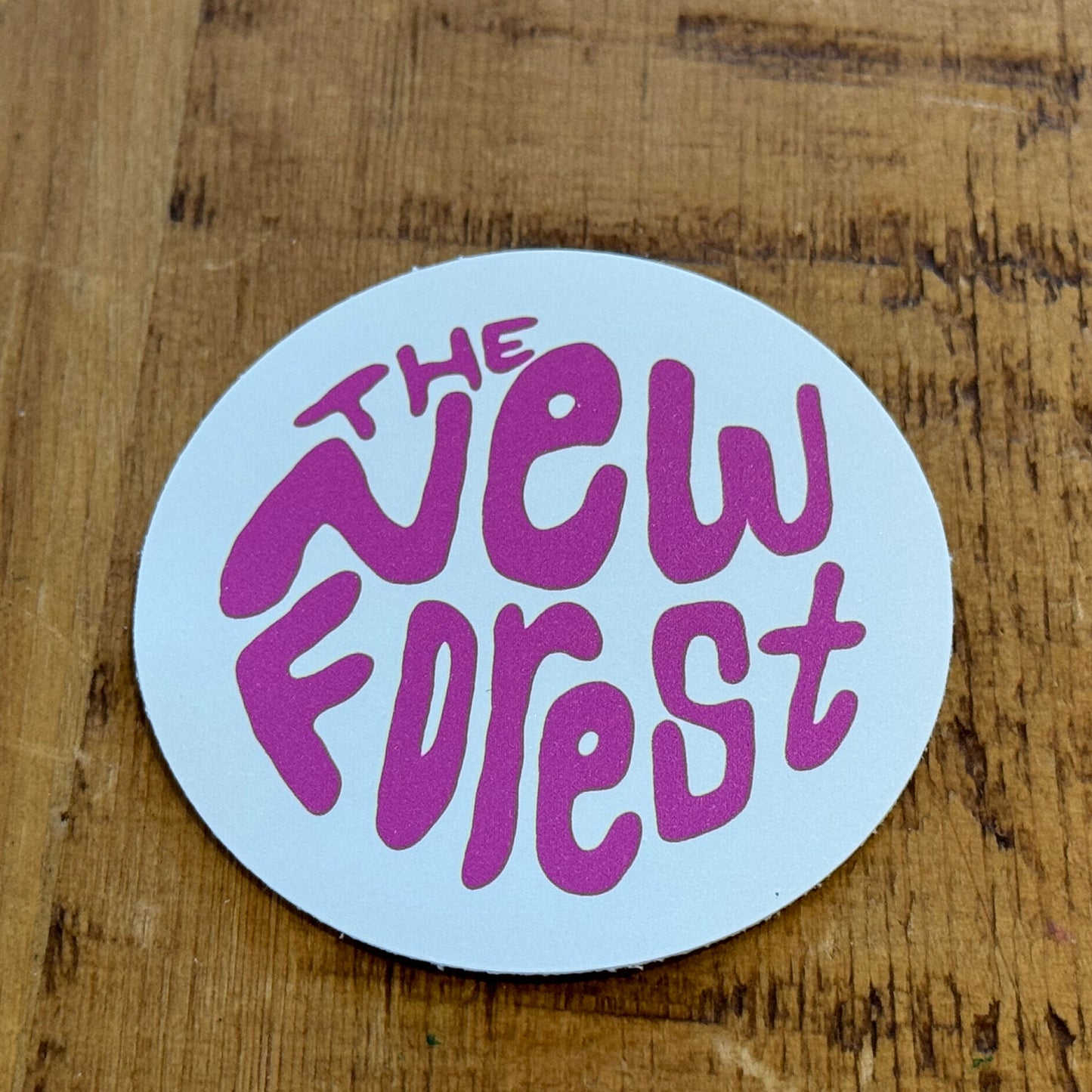 The New Forest Typography Circle Sticker (Solid) Pink/White on Desk