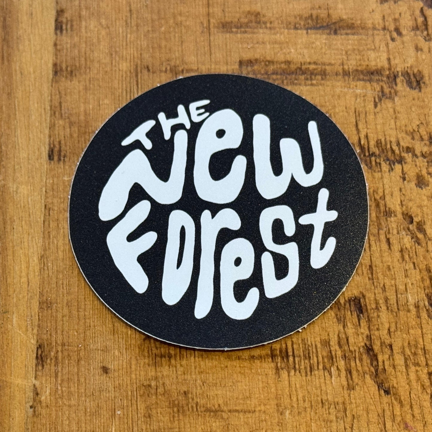 The New Forest Typography Circle Sticker (Solid) White/Black on Desk
